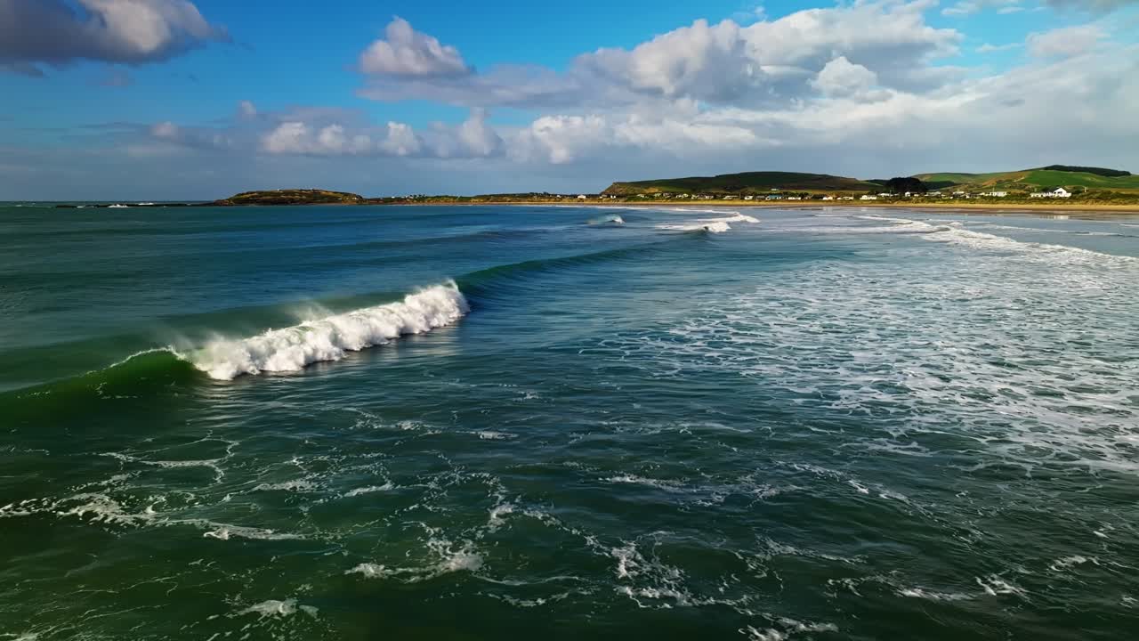 pan de camiones aéreos sigue el agua verde azul oscuro profundo que se eleva para romper en olas extendiendo la cal blanca