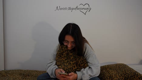 chica en la cama con el teléfono, riendo