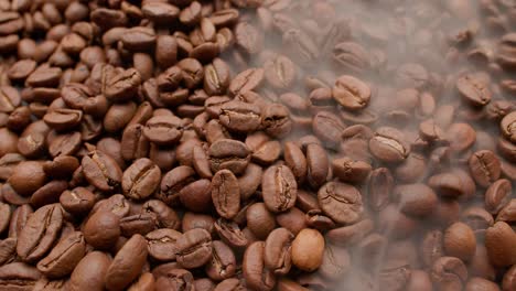 cerca de las semillas de café. los granos de café perfumados son tostados el humo viene de los granos de café.