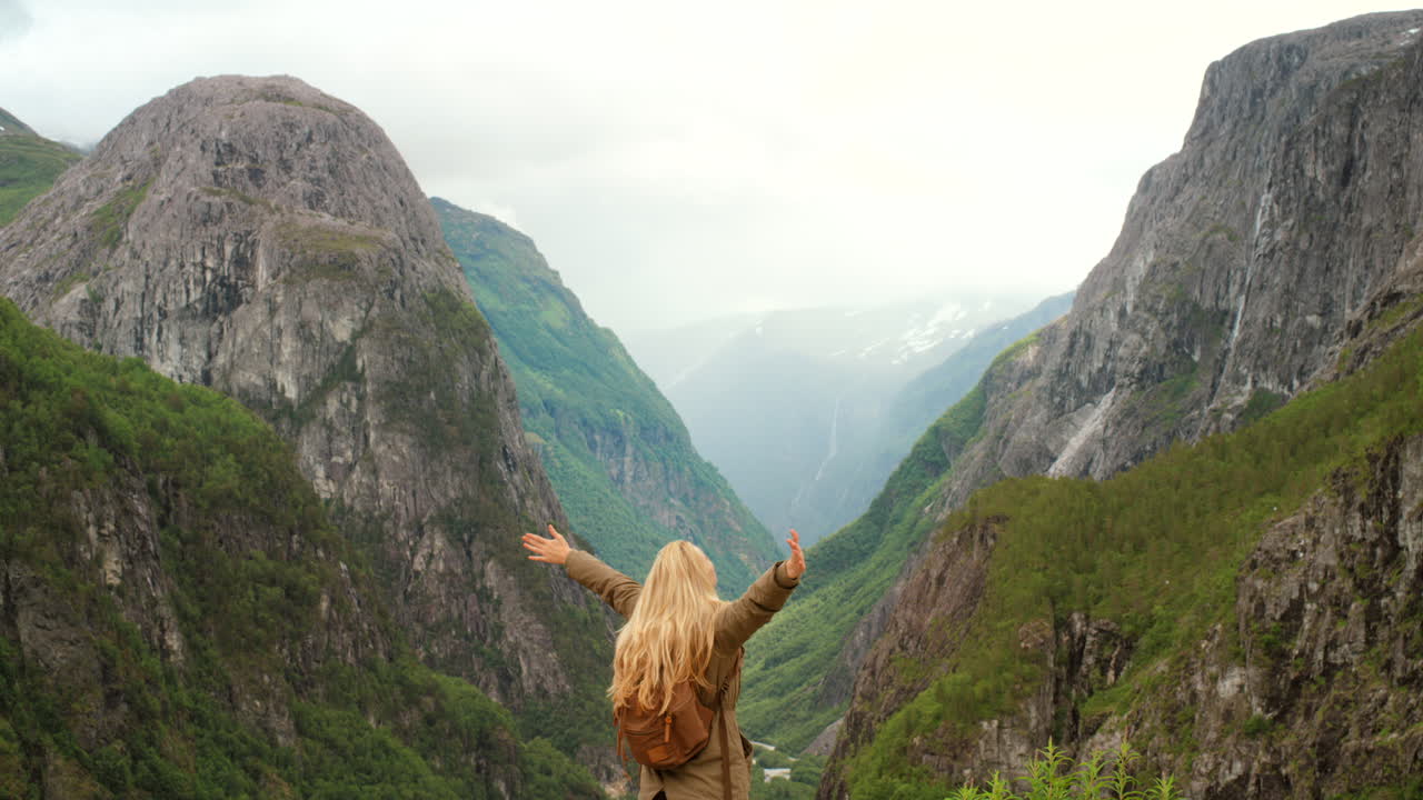mujer disfrutando de la vista desde un fiordo noruego
