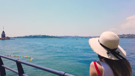 beautiful girl takes pictures of bosphorus and maidens tower in uskudar town,istanbul,turkey