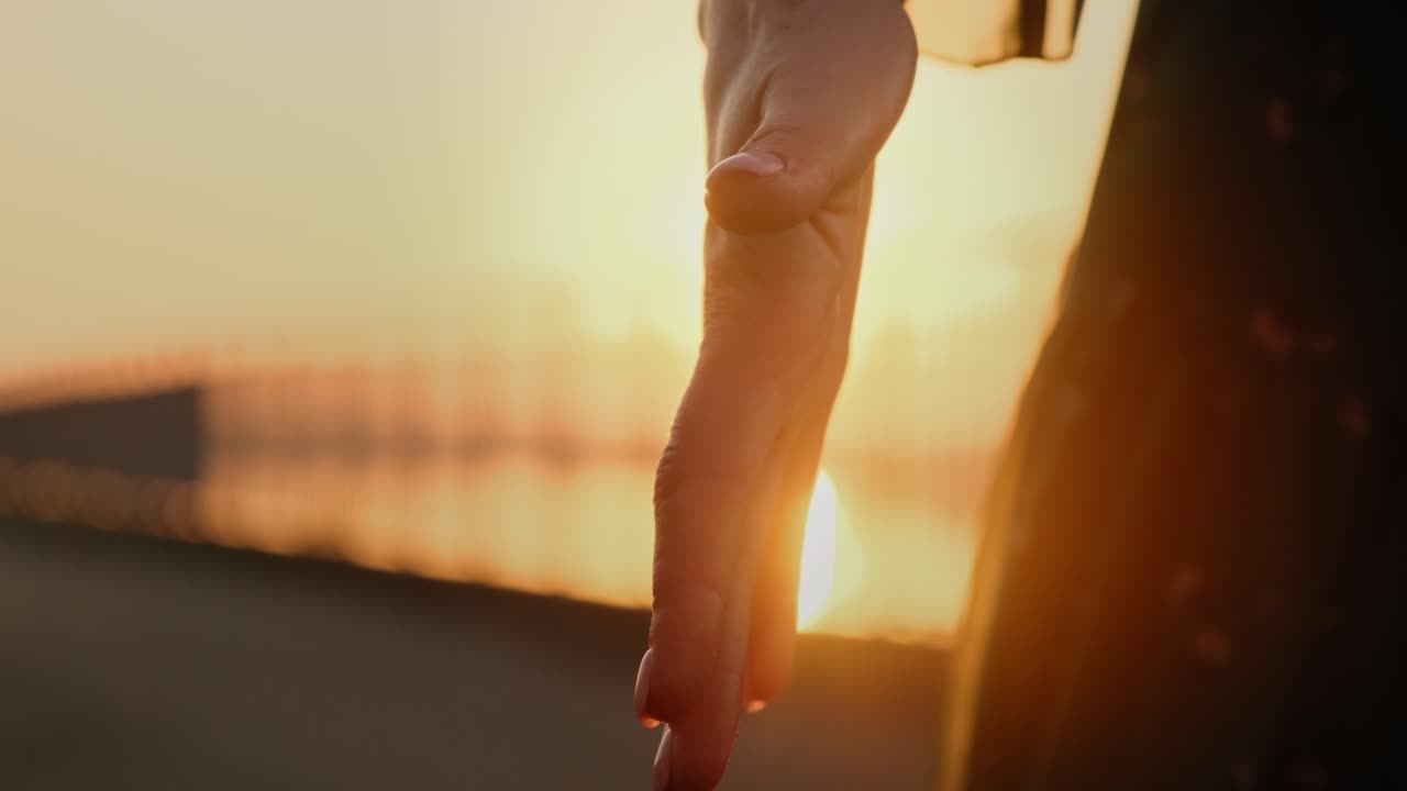 Hand Reaches Out to the Golden Sunset