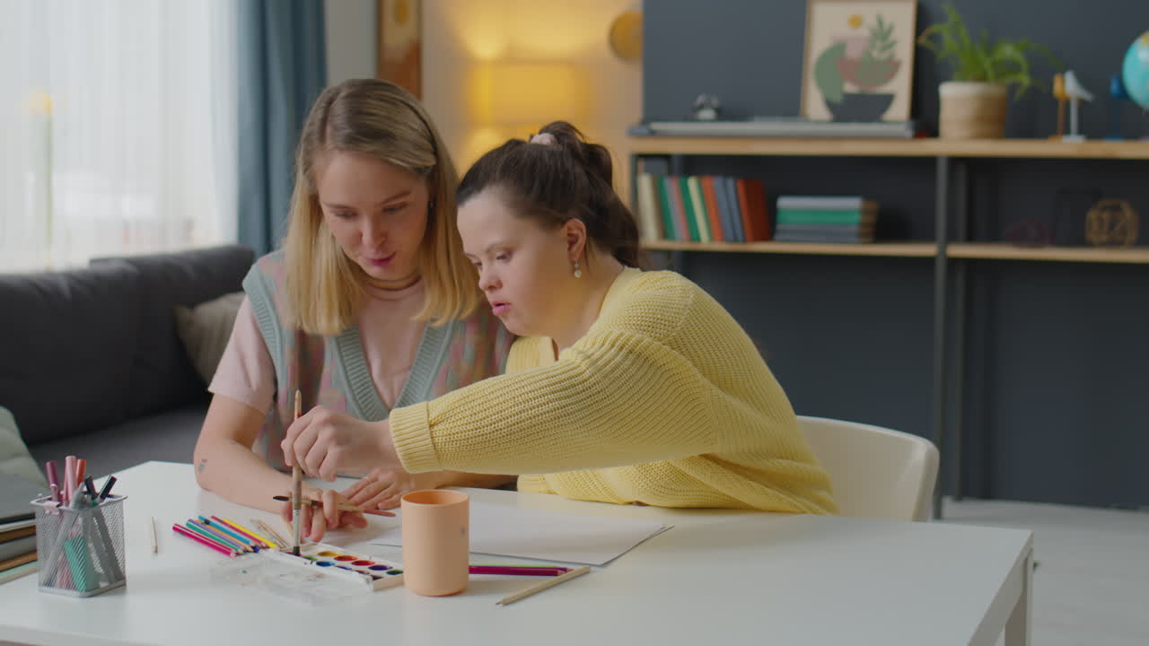 Girl with Down Syndrome Having Art Class with Teacher