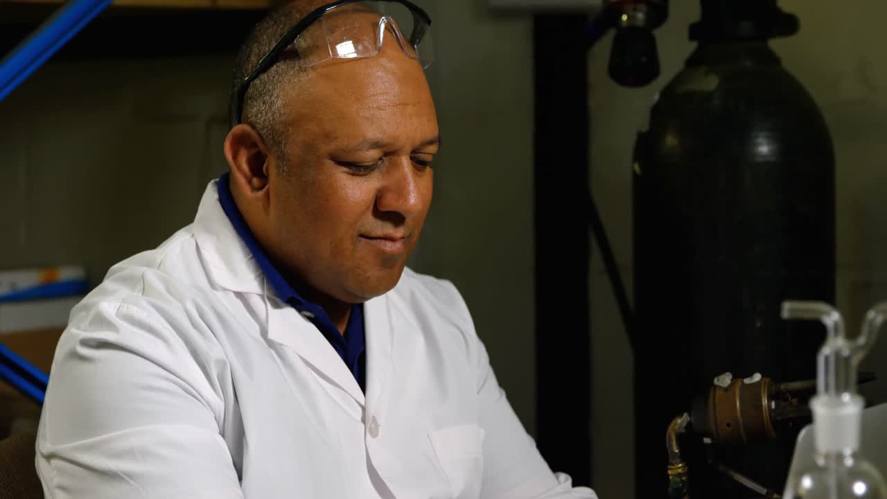 trabajador indio maduro atento usando una computadora portátil en una fábrica de vidrio 4k