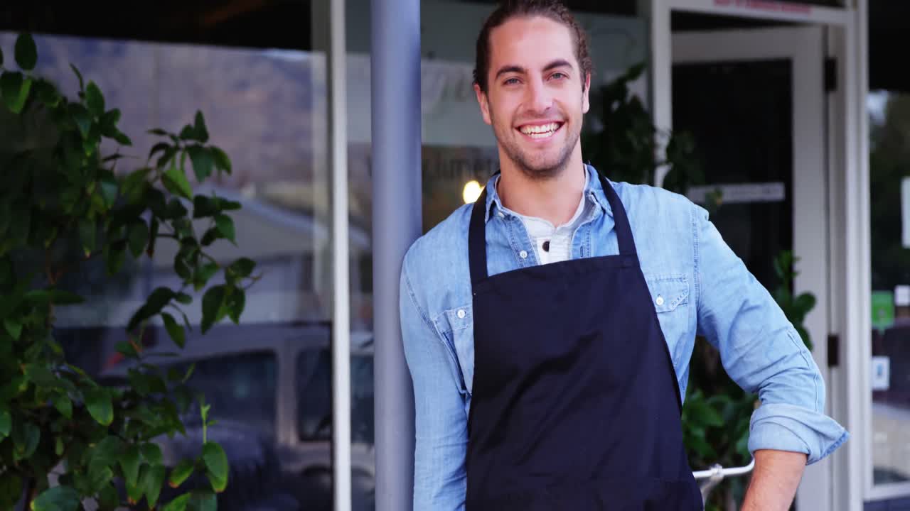 Kellner steht vor dem Café