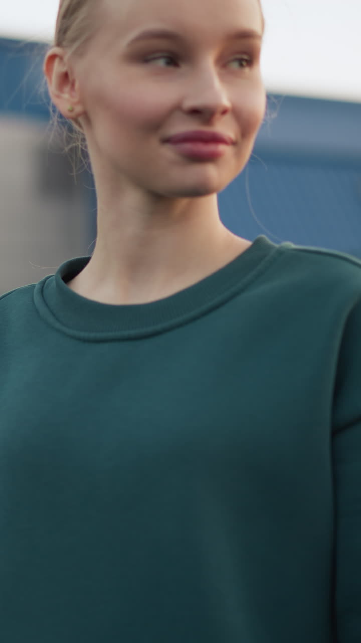 entrenador de entrenamiento de voleibol principiante, demostrando la técnica de servicio como prácticas de principiante, ambos de pie en la cancha al aire libre con voleibol en la mano con el edificio en el fondo