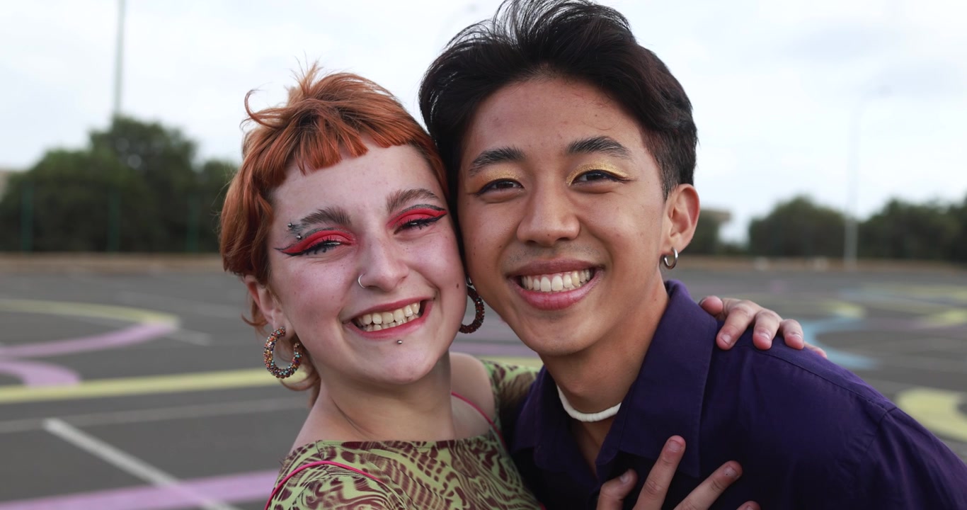 Happy Diverse Young Couple Embracing and Smiling at Camera
