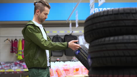 man looking at tires in a store