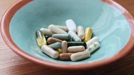 a small blue ceramic bowl full of health supplements