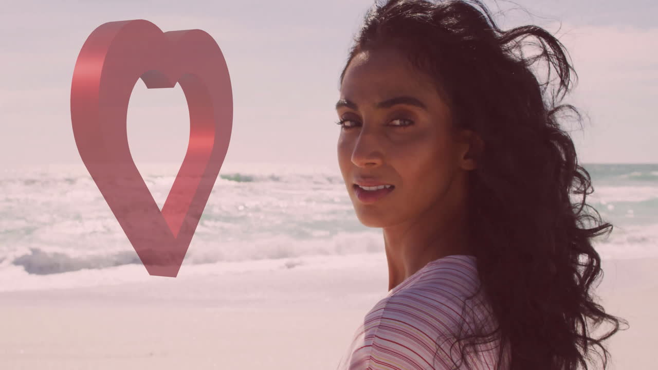 Woman with flowing hair standing on beach with heart-shaped animation