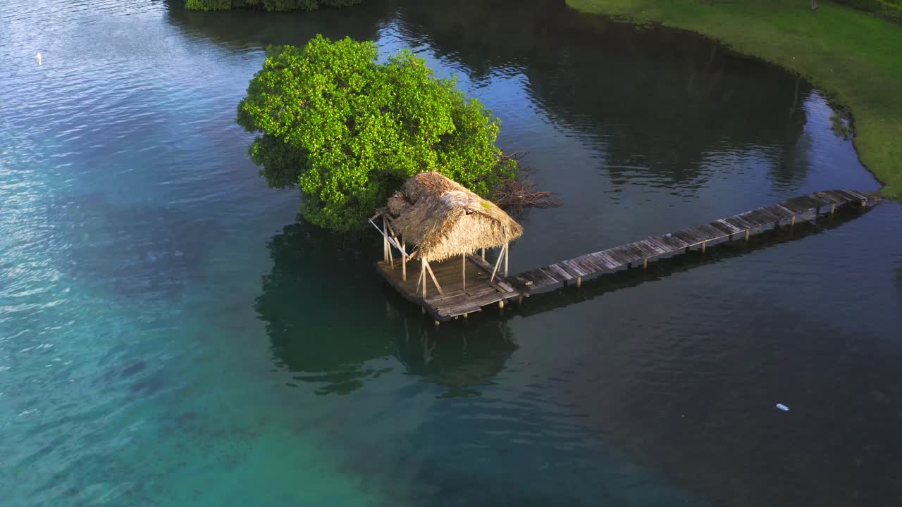 vista aérea sobre una simple cabaña de playa con techo de paja de bambú de madera - embarcadero en la costa de panamá