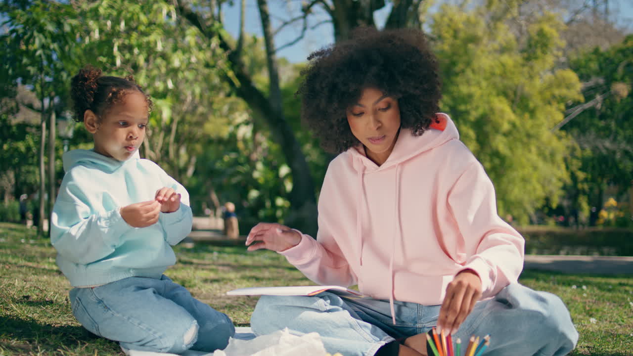 hija comiendo picnic en el césped verde de cerca. fin de semana familiar