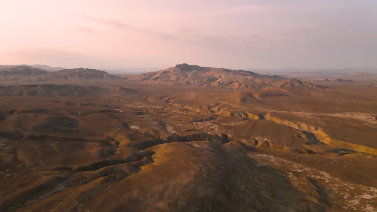 아제르바이잔의 쿠부스탄 국립공원 사막 위를 날아다니는 드론이 해가 지는 산을 향해 습니다.