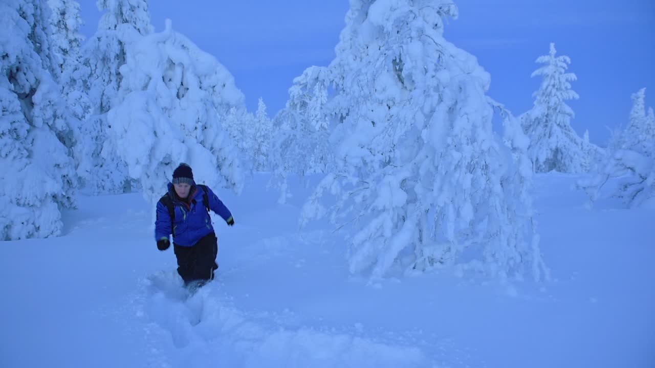 Hiking through the thick white snow of Lapland, Finland - wide shot