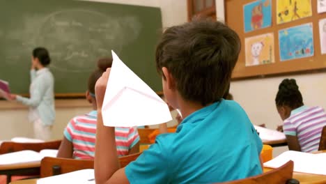 Child-with-paper-plane-in-the-hand-during-the-lesson