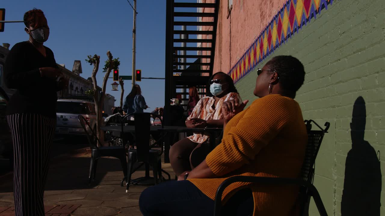 Group of friends socializing in the street during Artsapalooza - Americus First Friday Art Event Sumter County Georgia