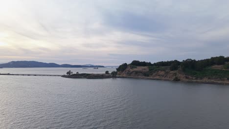 elevated drone view of point molate showcases the gentle curve of shoreline and the calm waters beyond.