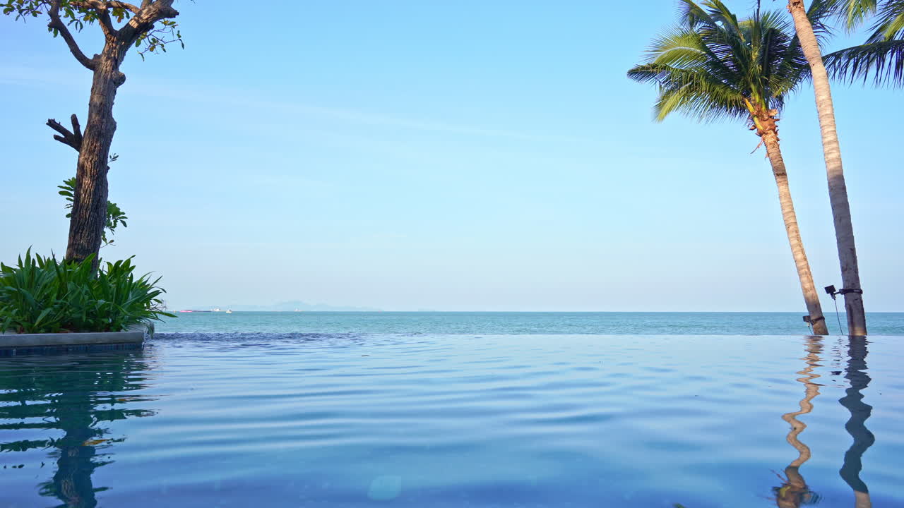 Peaceful seaside scene from infinity pool overlooking a tropical beach