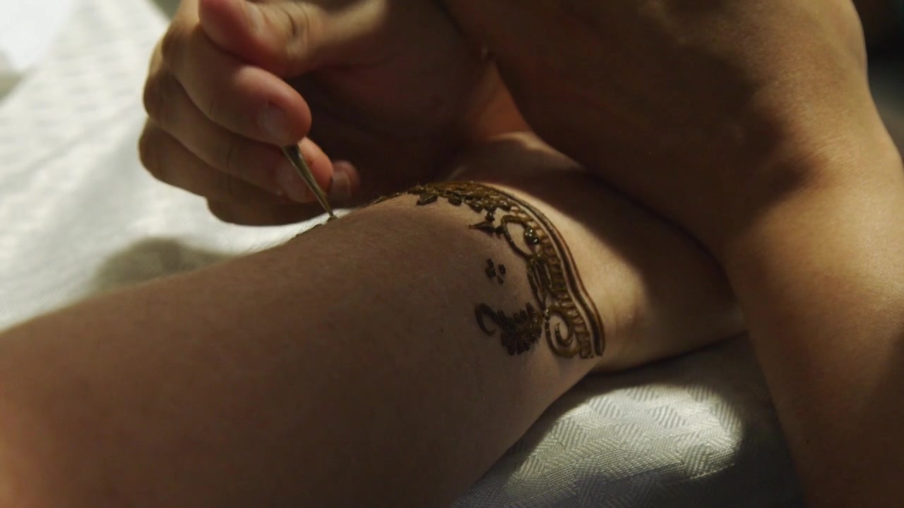 Tatuaggio all'henné applicato sul braccio di una donna con un disegno tradizionale asiatico.