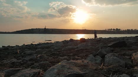 A-man-bass-fishing-in-a-lake-during-a-calm-sunny-afternoon