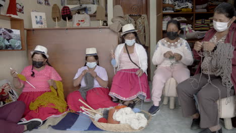group of indigenous women knitting with wool thread