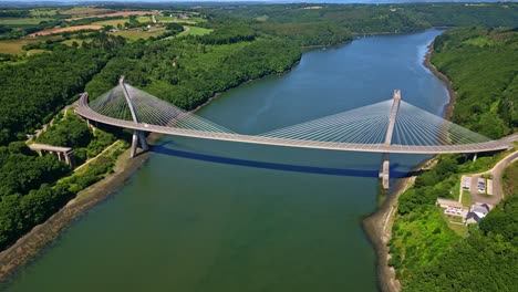 modern térénez bridge over aulne river, cable-stayed structure surrounded by lush green forest and countryside, brittany, france. aerial drone pov