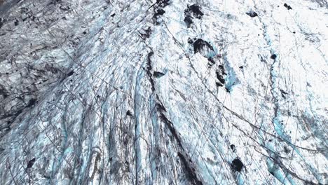 aerial-drone-view-of-an-impressive,-gigantic-glacier-in-volcanic-rock-on-the-island-of-Iceland,-with-mountains-on-its-sides