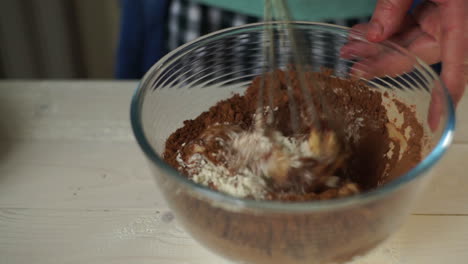 cooking cake. man hands whisking ingredients in glass bowl in slow motion