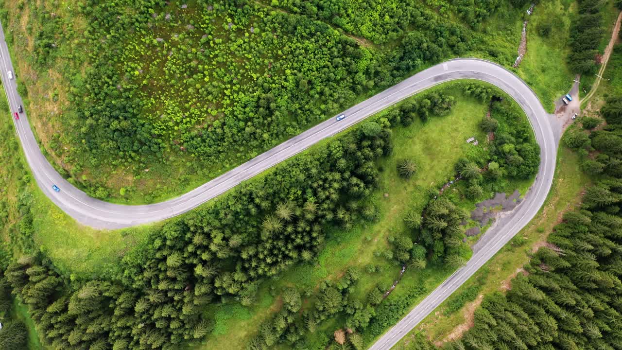 vista aérea de drones de arriba hacia abajo de los automóviles que conducen en una hermosa carretera curva en las montañas del parque nacional de los bajos tatras en eslovaquia