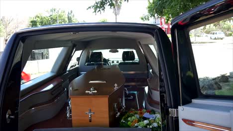 closeup shot of a funeral casket in a hearse or chapel or burial at cemetery