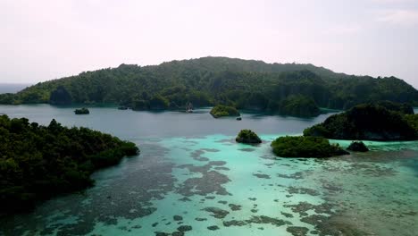 Reef-between-islands-in-Piaynemo-on-Raja-Ampat-Indonesia,-Aerial-lowering-approach-shot