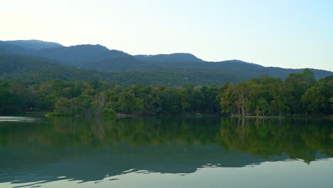 Lago-Ang-Kaew-En-La-Universidad-De-Chiang-Mai-Con-Montaña-Boscosa-Y-Cielo-Crepuscular