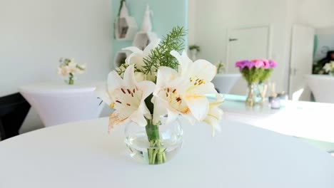 un hermoso arreglo de flores de lirio blanco en un jarrón de vidrio