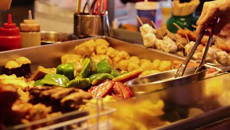 vendor preparing skewers at a food stall