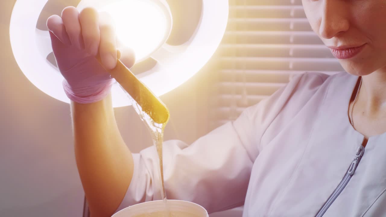 설탕 머리카락을 들고 있는 여성 페이스트를 제거합니다. 아름다움 개념. 설탕. 탈모 과정.