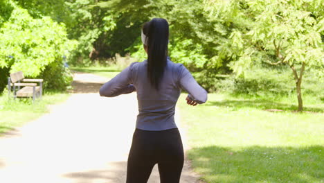 Young-Woman-Stretching-Before-Exercising-Running-Through-City-Park-Wearing-Wireless-Earbuds-2