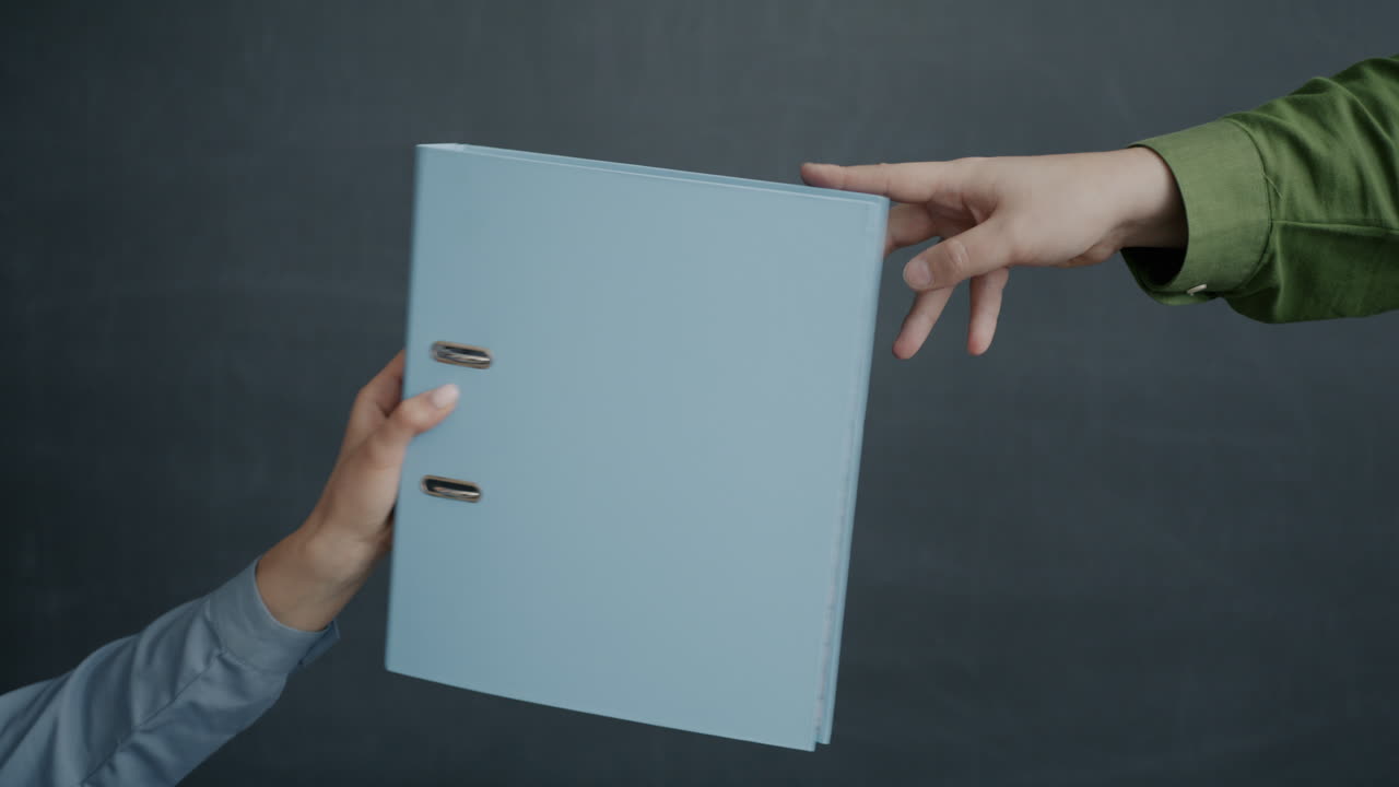 Two hands exchanging a light-blue file folder