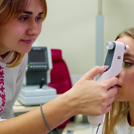 beautiful woman at the ophthalmologist's consultation . female specialist examines patient's eyes with a special device in modern medical center.
