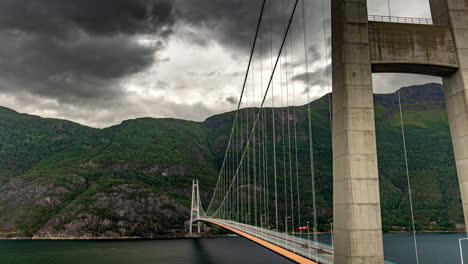 time lapse of traffic flow and moody clouds over hardanger bridge, vestland