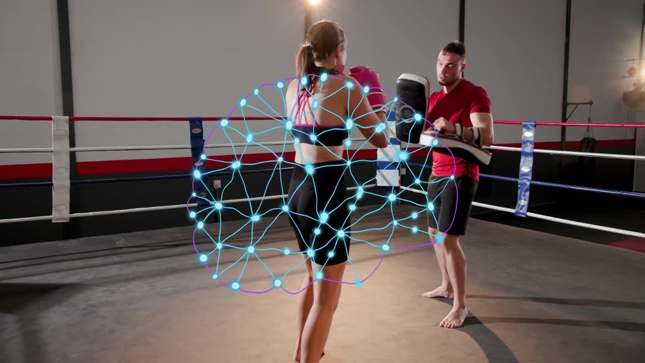 Female boxer moving with pink gloves, coach offering pads, boxing drills while blue net tracking