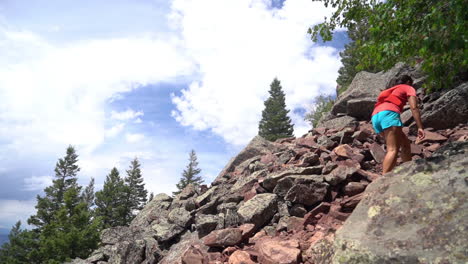 woman walking uphill on rocks, boulder skyline traverse hiking trail, colorado, usa