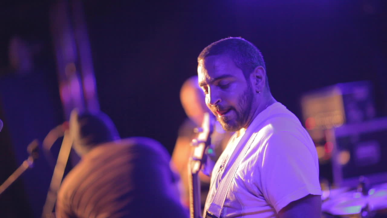 Guitarist performing on stage at a rock concert.