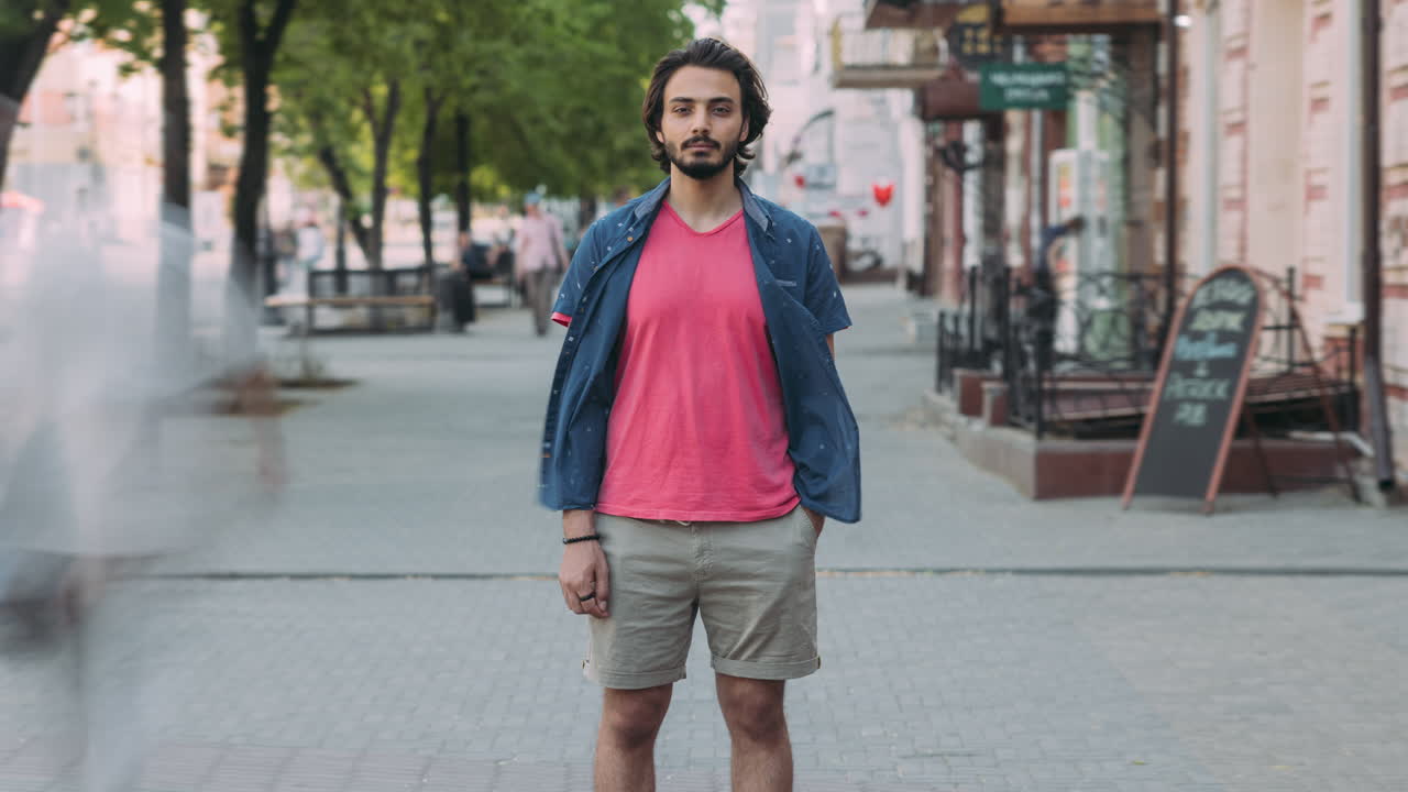 Man in pink shirt and shorts on city street