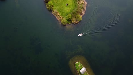 vista aérea desde arriba de un barco que cruza un canal de agua entre dos islas - vista aérea de un barco rápido que cruza aguas marinas cristalinas de color azul con pequeñas islas tropicales