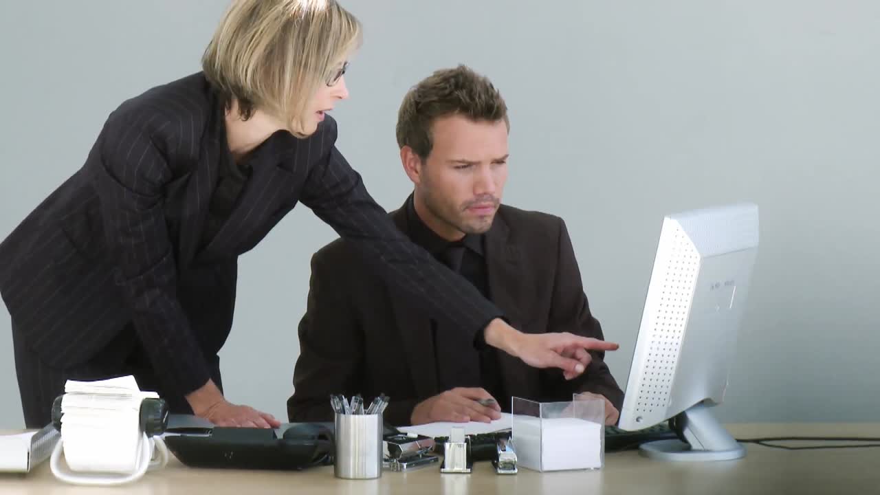 Two associates discussing over a desktop