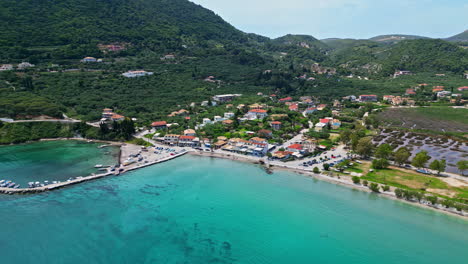 aerial view of a coastal town with turquoise water and green hills