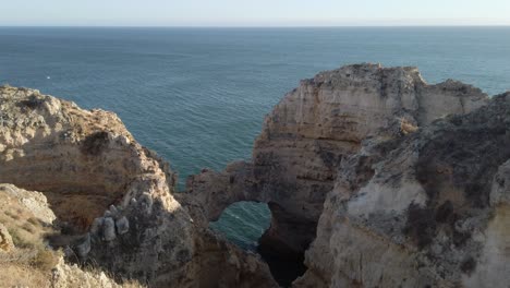 Natural-archway-in-limestone-rock-formations-along-Portuguese-coastline,-Lagos,-Portugal