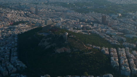 Toma-Aérea-Dando-Vueltas-Alrededor-Del-Mirador-Más-Alto-De-Atenas,-La-Colina-Lycabettus.