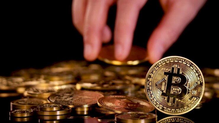 Una mano lascia cadere una moneta Bitcoin dorata su una pila di monete, illuminazione drammatica, primo piano, sfondo nero