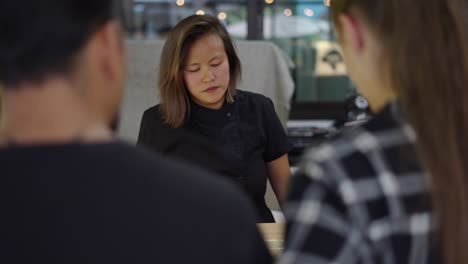 three people engaged in a conversation or meeting indoors